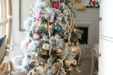20 a flocked Christmas tree in a wooden box and decorated with colorful ornaments with a vintage feel