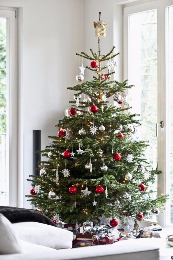 a traditional Christmas tree with white, red, metallic ornaments, balls, snowflakes and stars