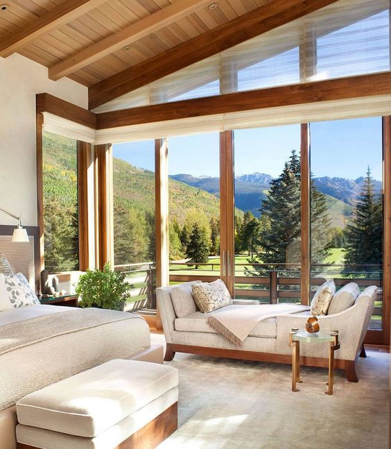 a modern rustic bedroom in neutrals plus contrasting wood and extensive glazing to enjoy the views