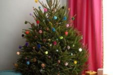 21 a small Christmas tree decorated only with colorful pompoms and LEDs is a fun and whimsy idea