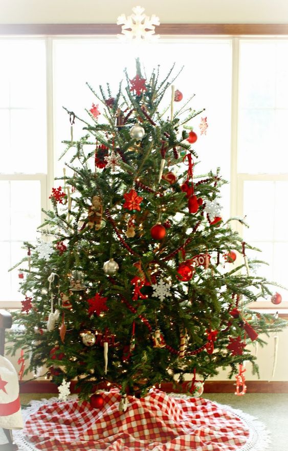 a traditional Nordic Christmas tree with metallic, red and white ornaments of various shapes and letters plus lights