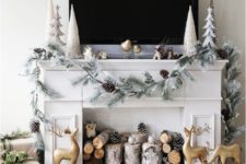 22 a mantel decorated with a snowy evergreens and snowy pinecones garland for a real winter feel