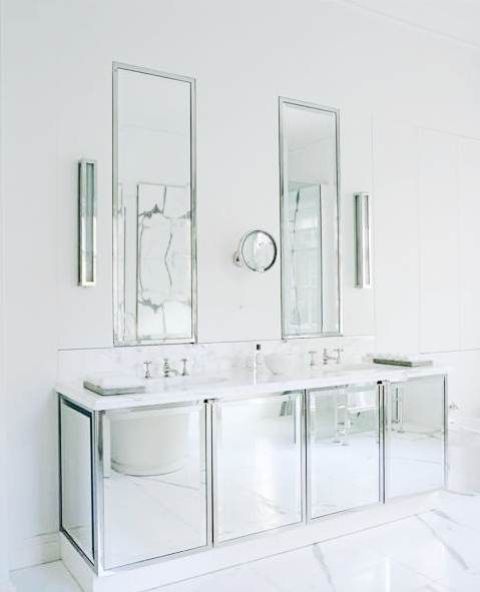 a minimalist solution with a mirrored vanity and two matching ones plus white marble everywhere around