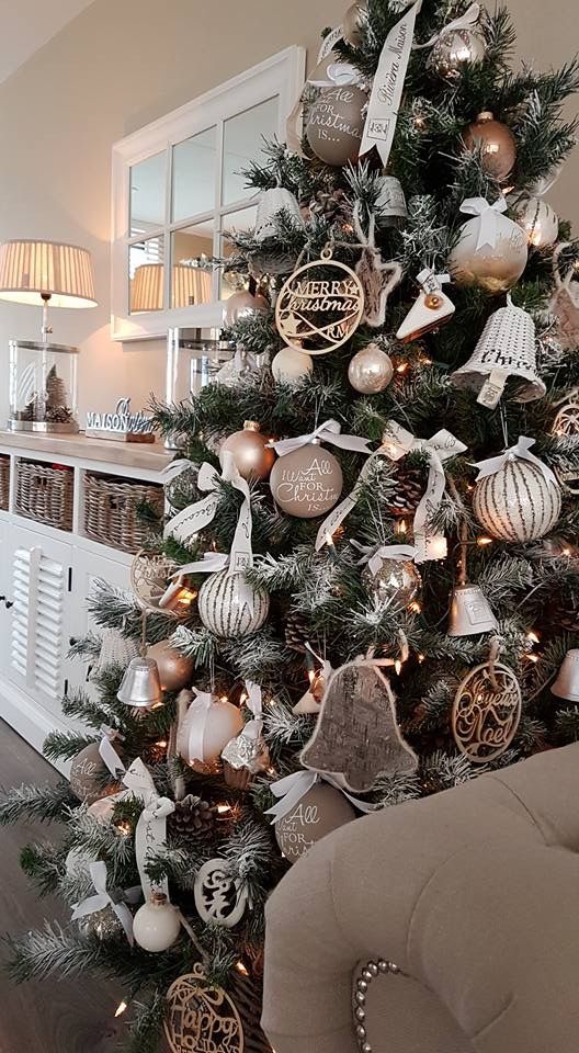 a glam rustic Christmas tree decorated with wicker bells, wooden and metal ornaments and some ball ornaments and pinecones