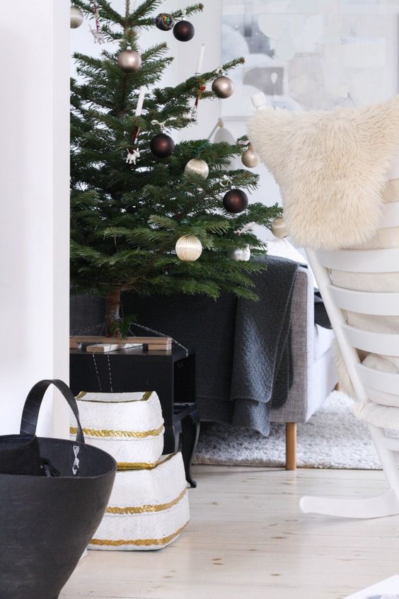 a small holiday tree with silver, pearly and chocolate ornaments plus fake candles