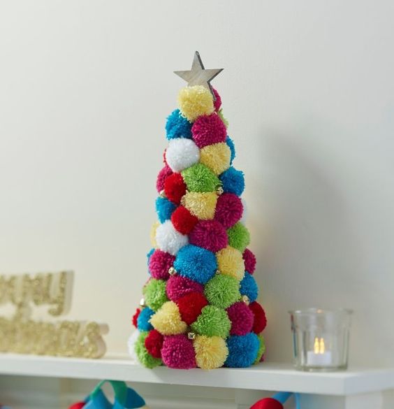 a super colorful pompom tabletop Christmas tree with beads and a star on top can be crafted in addition to a usual tree