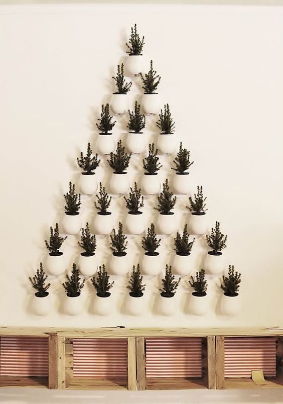 a super creative Christmas tree formed of potted evergreens that are attached to the wall