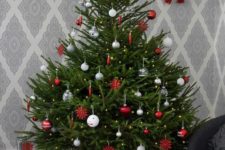 23 a traditional Nordic Christmas tree with white, silver, clear and red ornaments and a red star on top