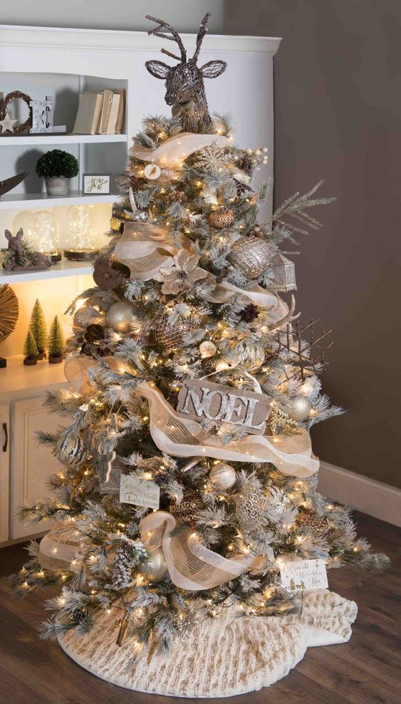 a rustic glam Christmas tree decorated with burlap, a vine deer head, wooden signs, stick snowflake ornaments and gold touches