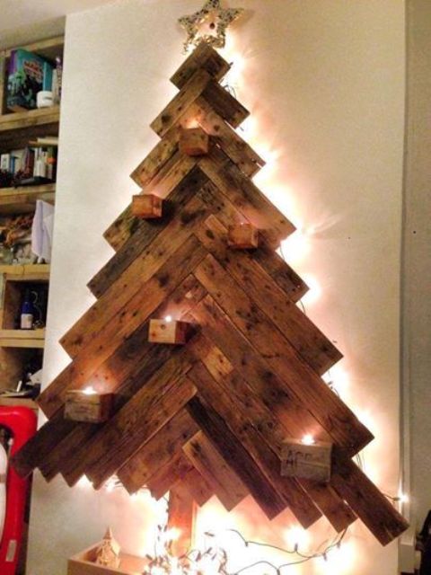 a wall-mounted reclaimed wood Christmas tree with inner lights and candle holders plus a star on top