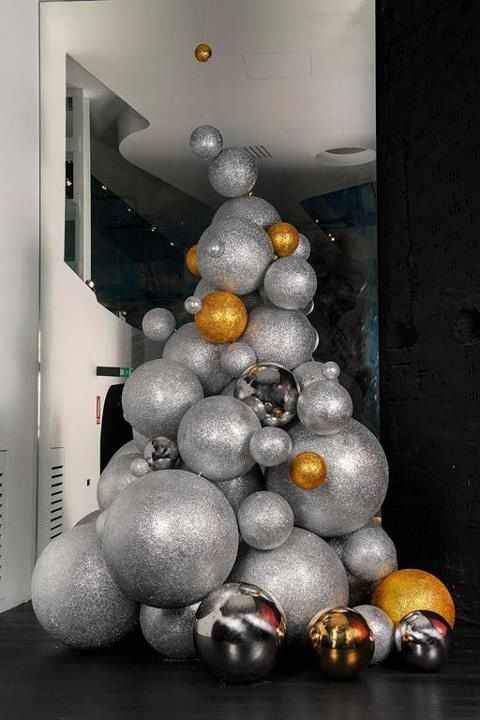 an oversized Christmas tree composed of oversized silver and gold glitter Christmas ornaments or balls will make a statement