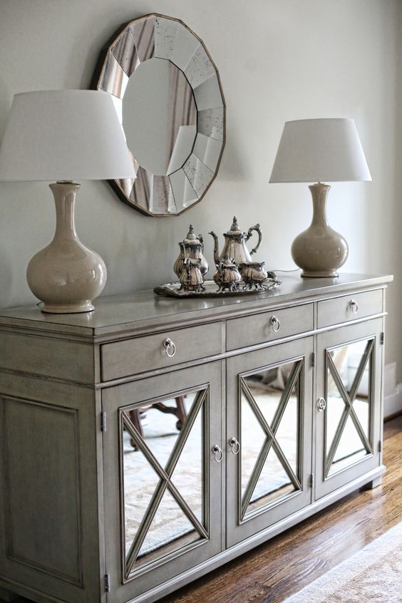 a vintage sideboard clad with mirror and with criss crosses for a refined and chic look