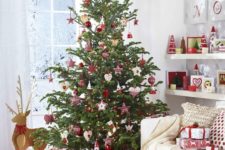 26 a traditional Scandinavian Christmas tree with various red and white ornaments and plaid decorations