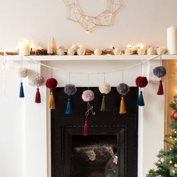colorful pompom and tassel garland plus a garland of white pompoms on the mantel