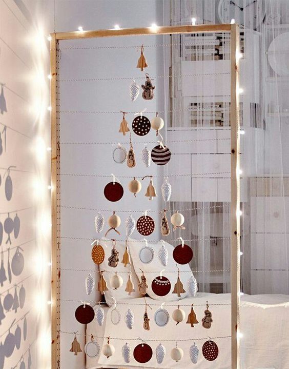 take a large frame, hang some yarn and form a Christmas tree of your favorite ornaments, line it up with lights
