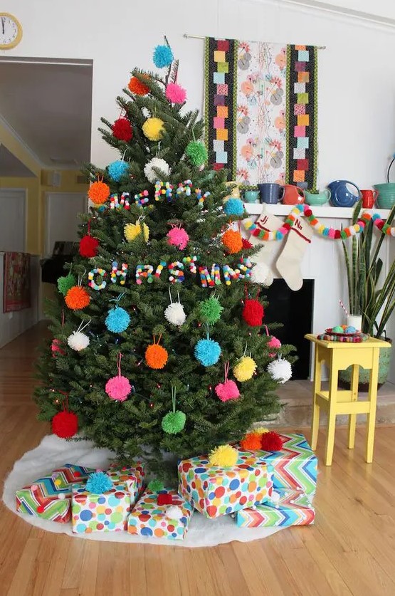 a Christmas tree with colorful pompom ornaments and colorful pompom letters is very awesome