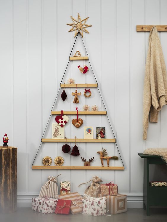 a cool wall-mounted Christmas tree composed of ledges hanging, with various decor and cards is a simple and cool idea for the holidays