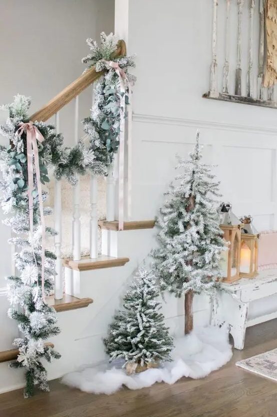 a lovely winter wonderland Christmas space with a snowy evergreen garland, a duo of flocked Christmas trees