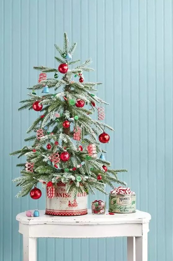 a retro-inspired tabletop Christmas tree with blue bells, red and green ornaments, buttons is a lovely idea for your space