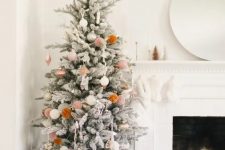 a simple and cute boho snowy Christmas tree with neutral ornaments and pompoms is a cool idea for a boho space
