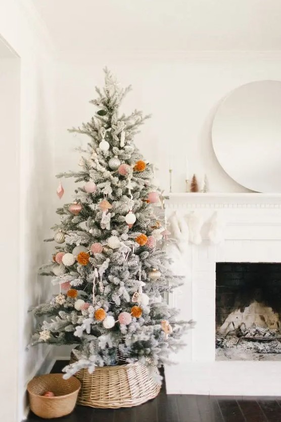 a simple and cute boho snowy Christmas tree with neutral ornaments and pompoms is a cool idea for a boho space