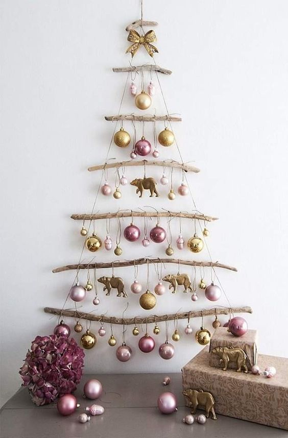 a simple and natural wall Christmas tree of branches and yarn, with pastel ornaments, is a lovely idea