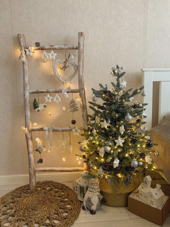 a small Christmas tree in a basket, with lights, white and silver ornaments and pinecones is amazing