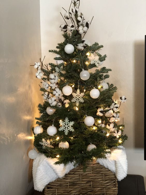a small Christmas tree with white baubles, snowflakes and cotton and lights is amazing to style your space