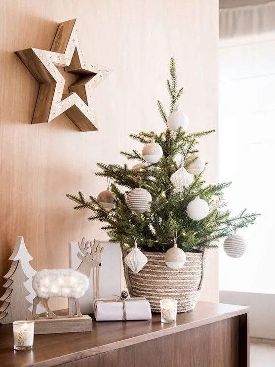 a stylish and simple small Christmas tree decorated with twine and color block neutral ornaments and put into a crochet basket