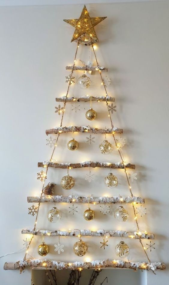 a wall-mounted Christmas tree made of branches and rope, with lights, ornaments and snowflakes is a cool idea