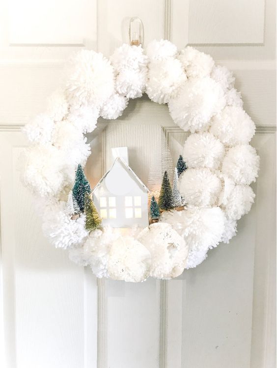 a white pompom Christmas wreath with bottle brush trees, a house is a cool and cozy solution