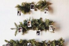 an alternative Christmas tree of evergreens and family pics is a very fresh and modern idea