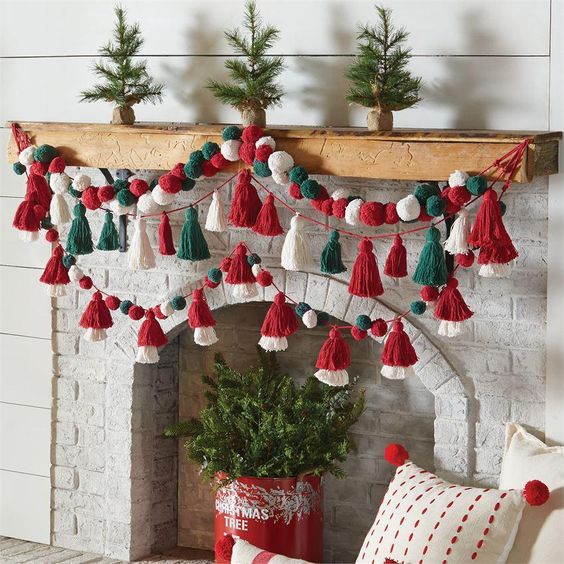 bright green, red and white pompom and tassel garlands on the mantel are a cool and fun decor idea