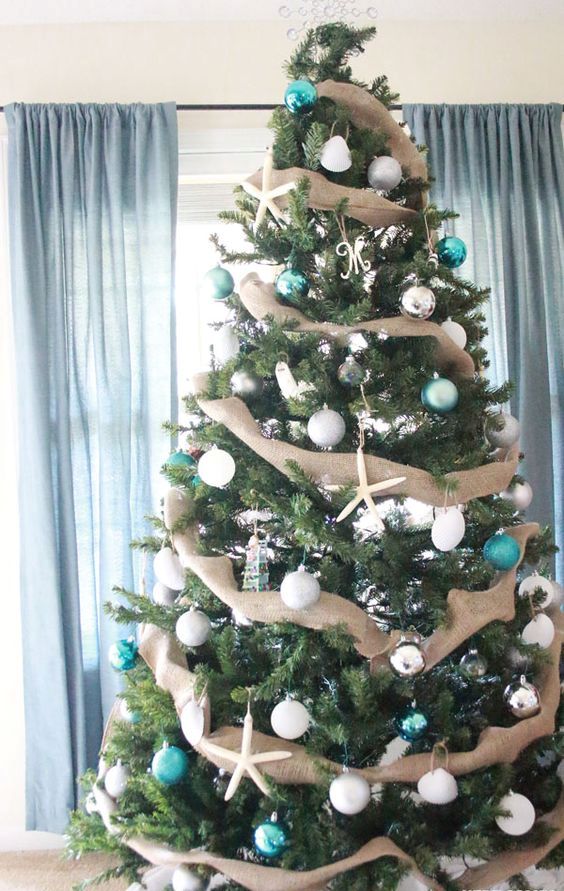 a beautiful Christmas tree with burlap garlands, white and turquoise ornaments plus star fish