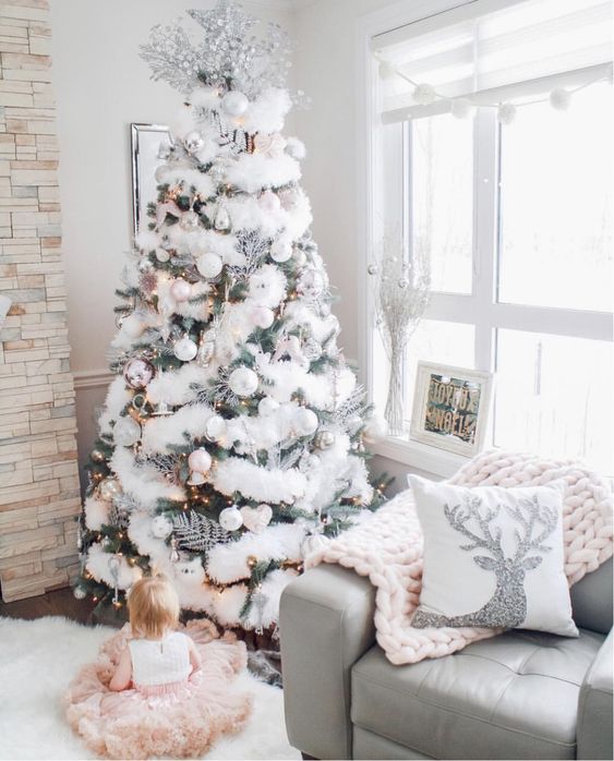 a flocked Christmas tree decorated with faux fur, silver leaves and pearl and white ornaments is super chic