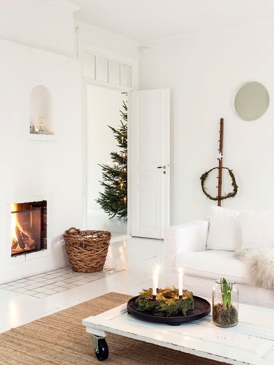 moss, candles, bulbs, a fireplace and a simple evergreen wreath create a cozy space with a touch of nature