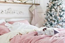 03 a classic red and green farmhouse Christmas bedroom with striped bedding, stockings and a snowy Christmas tree