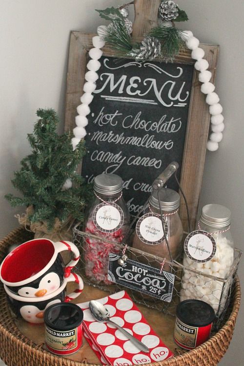 a small and cozy hot chocolate station with penguin mugs and a chalkboard menu