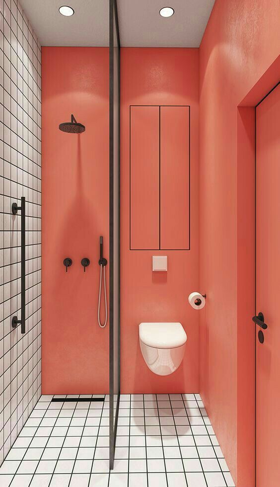 coral walls contrast white tiles with black grout to make up a bold and unusual bathroom