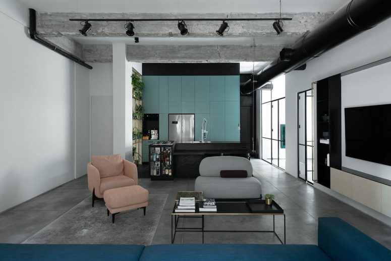 The kitchen features mint blue cabinets and a black kitchen island with a bar as one of the owners is a chef