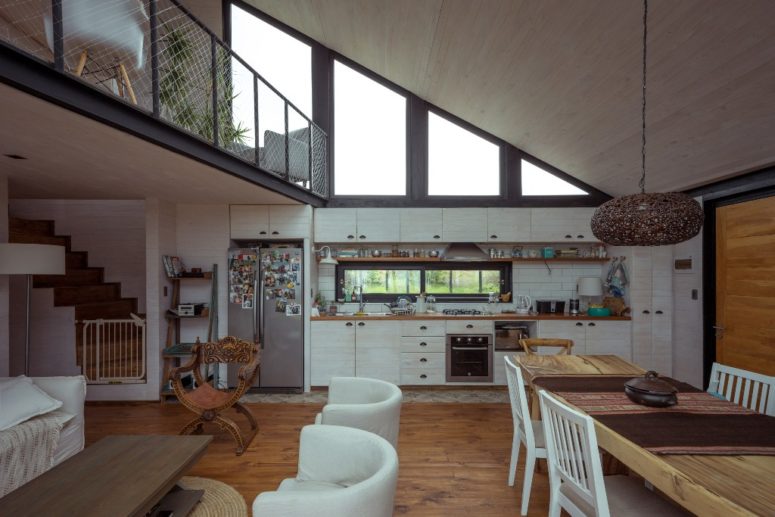 The main space is an open layout with a kitchen, dining zone and living room in one, plus there's a balcony over it