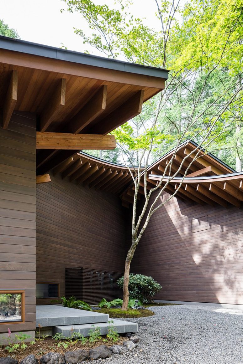 This is an entrance courtyard with an acer palmatum tree, careful landscaping and gravel in the yard
