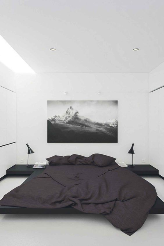 a modern laconic space in black and white with skylights, floating nightstands and a large floating bed in black