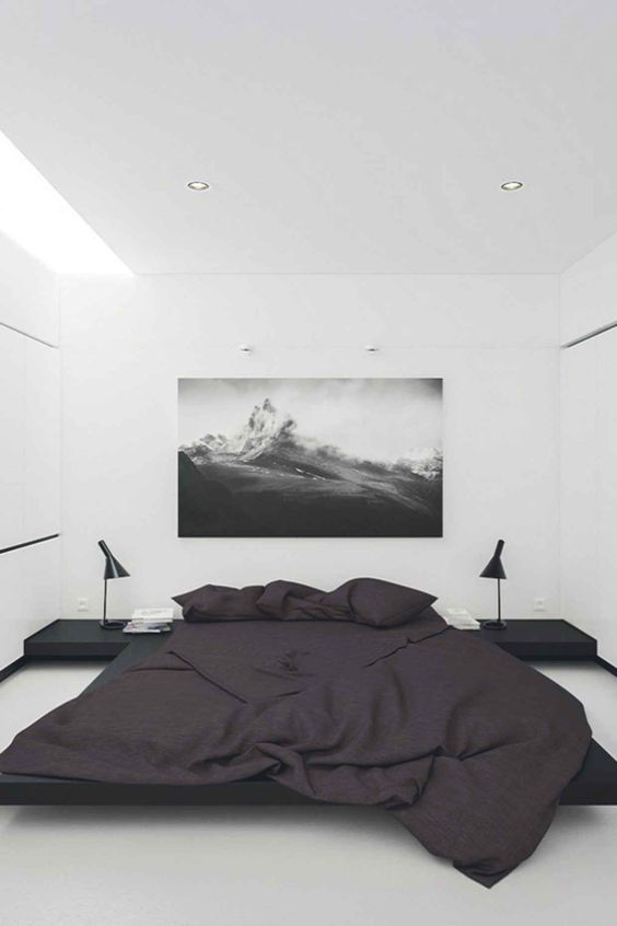 a modern laconic space in black and white with skylights, floating nightstands and a large floating bed in black