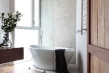 04 a modern rustic bathroom with a free-standing sculptural bathtub and large yet frosty glass windows for natural light