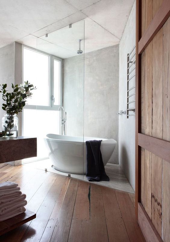 a modern rustic bathroom with a free standing sculptural bathtub and large yet frosty glass windows for natural light a modern rustic bathroom with a free-standing sculptural bathtub and large yet frosty glass windows for natural light