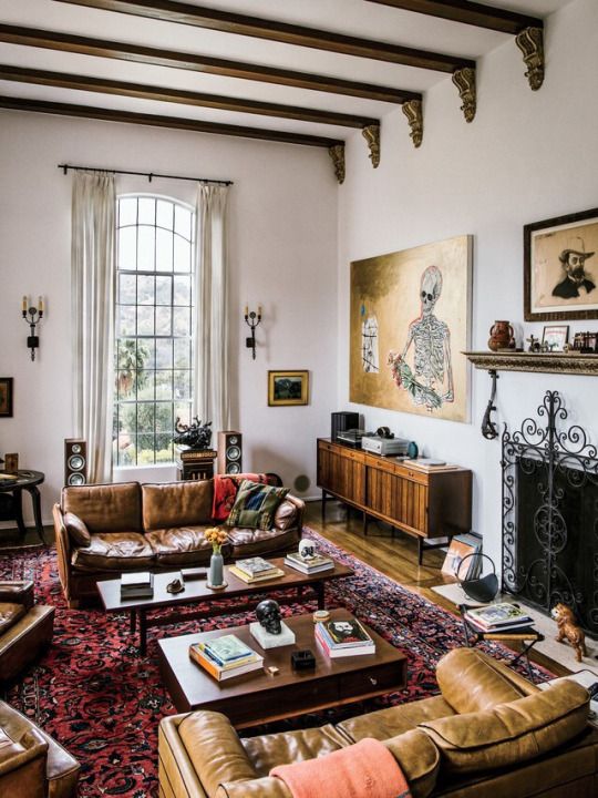 an electic living room with modern furniture balanced with vintage artworks and boho chic rugs