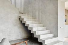 05 a minimalist entryway with a concrete staircase and timelessly elegant furniture