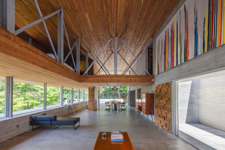 There's a large open layout done with concrete, wood and metal and with a colorful wall and furniture, it's multifunctional and practical feeling spacious