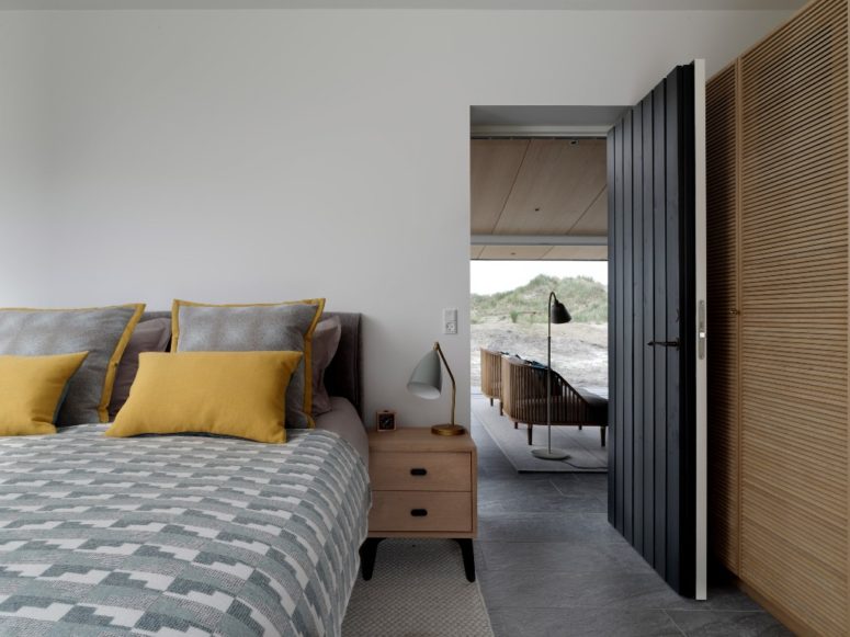 The bedroom is done with a comfy bed and some storage items clad with wood or plywood
